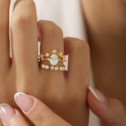 Oval ring on 18K gold vermeil band with 6 small cubic zirconia in the band stacked with a half eternity ring and V - shaped ring.