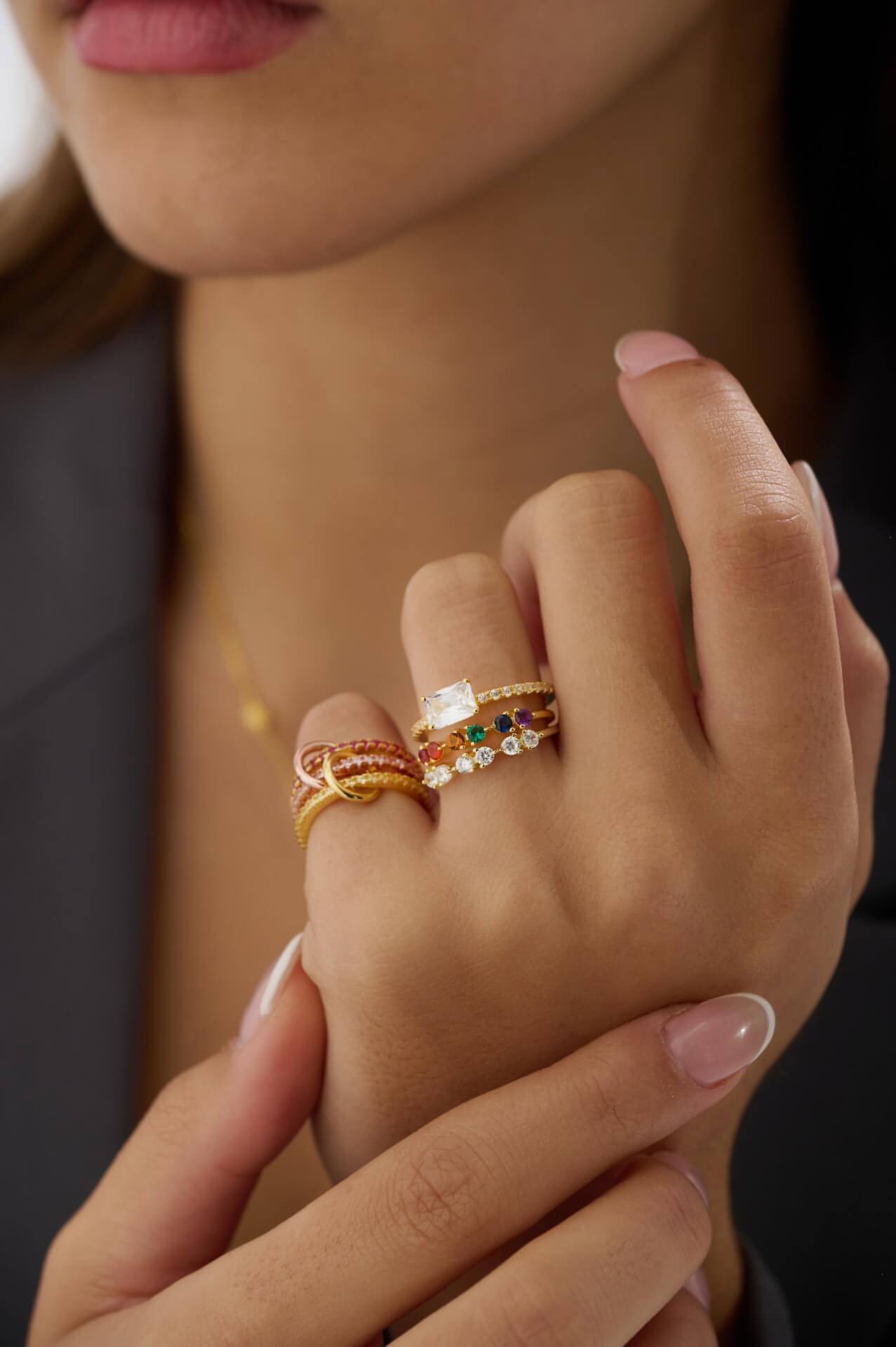 East west rectangle cubic zirconia with pave ring band stacked with half eternity cubic zirconia ring and half eternity rainbow ring. On pinky finger pink stacking ring will 3 layers. All in 18K gold vermeil.